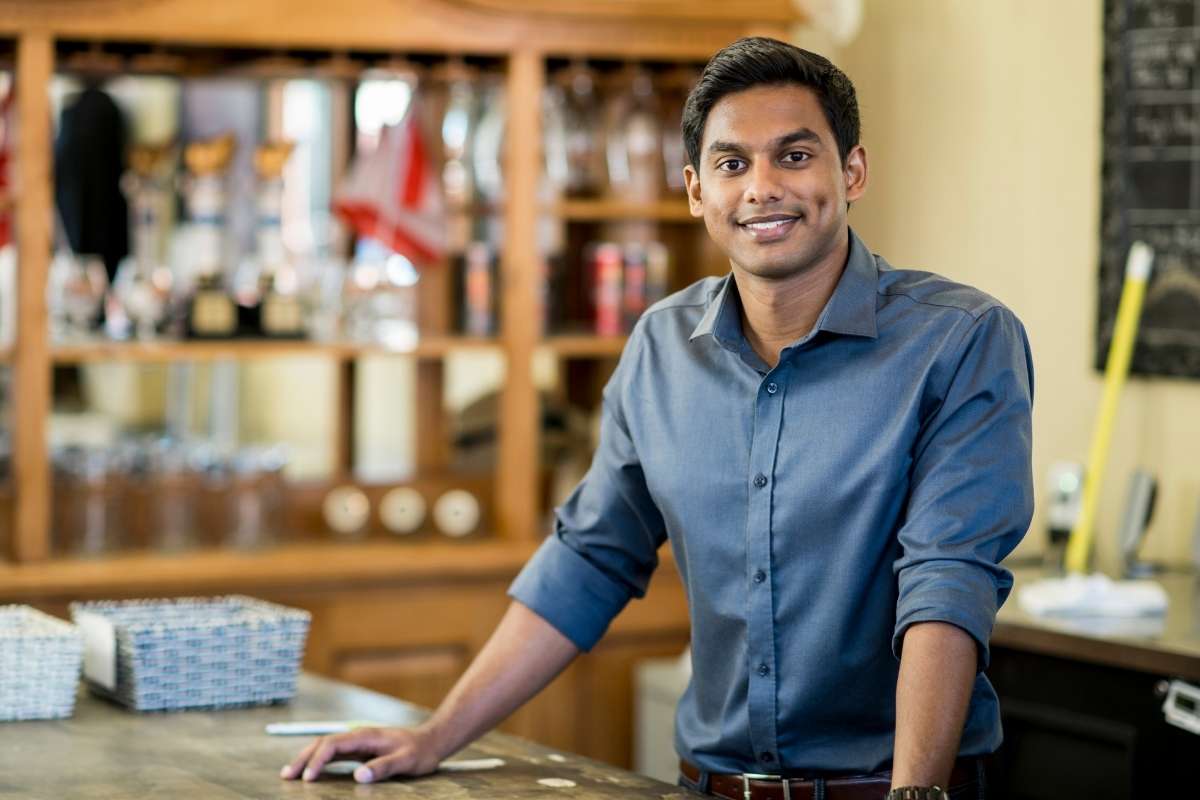 Indian man standing at counter at a business